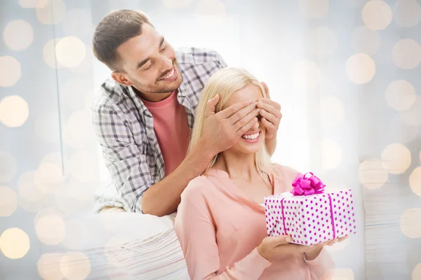 Homem feliz dando mulher caixa de presente em casa — Fotografia de Stock