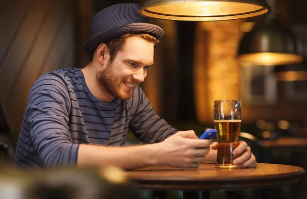 Homme avec smartphone et bière textos au bar — Photo