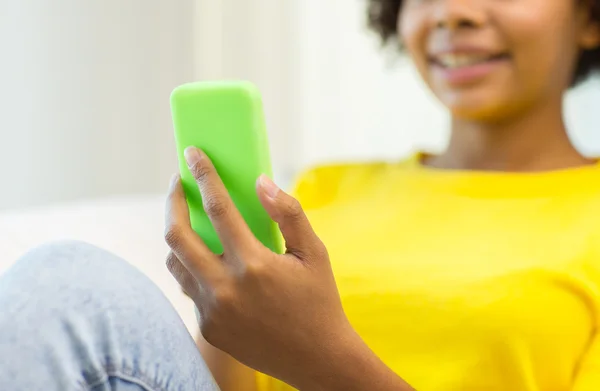 Femme africaine heureuse avec smartphone à la maison — Photo