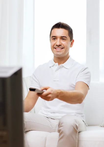 Sonriente hombre con control remoto viendo la televisión Imágenes de stock libres de derechos