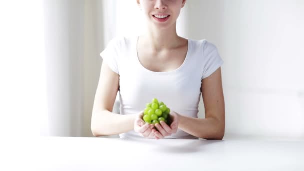 Крупным планом молодая женщина показывает зеленый гроздь винограда — стоковое видео
