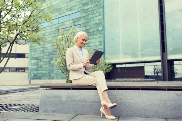 Uśmiechnięta kobieta z komputera typu tablet na zewnątrz — Zdjęcie stockowe