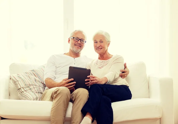 Feliz casal sênior com tablet pc em casa — Fotografia de Stock