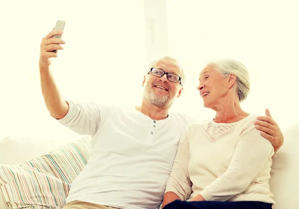 Casal sênior feliz com smartphone em casa — Fotografia de Stock