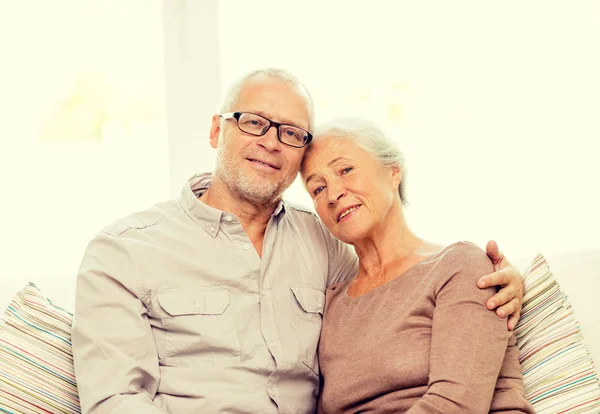 Feliz pareja de ancianos abrazándose en el sofá en casa —  Fotos de Stock