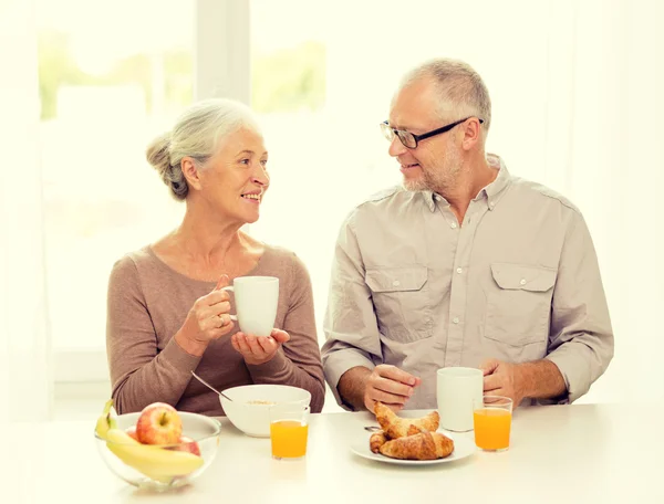 Happy senior couple having breakfast at home — Stock Photo, Image