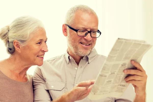 Happy senior couple reading newspaper at home — Stock Photo, Image