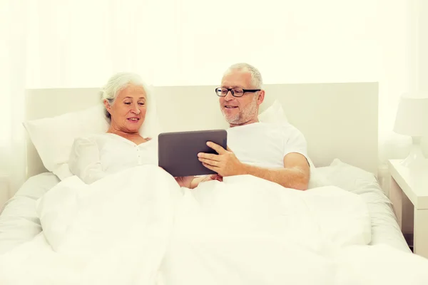 Feliz pareja de ancianos con PC tableta en casa — Foto de Stock