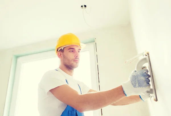 Builder with grinding tool indoors — Stock Photo, Image