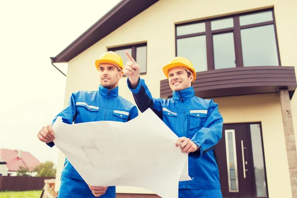 Group of builders with blueprint pointing finger — Stock Photo, Image