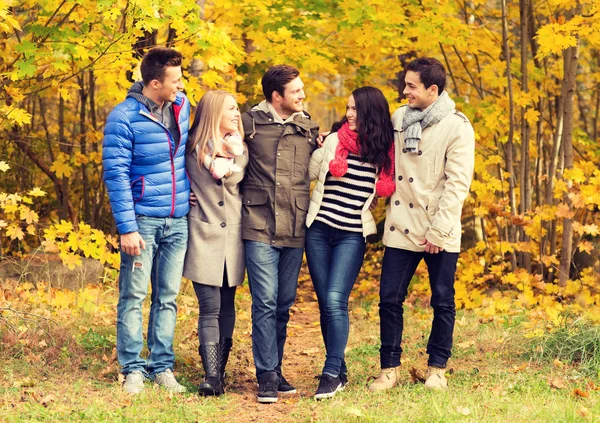 Grup gülümseyen kadın ve erkek sonbahar park — Stok fotoğraf