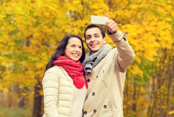 Glimlachend paar knuffelen in de herfst park — Stockfoto