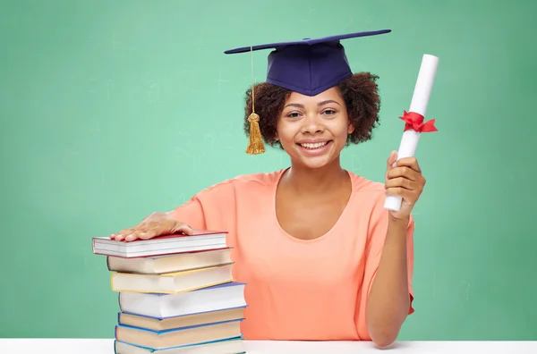 Happy african bachelor girl with books and diploma — Stock Photo, Image