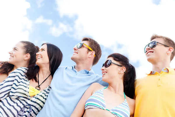 Grupo de amigos felices abrazándose en la playa — Foto de Stock