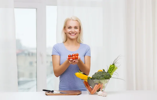 若い女性が自宅に野菜を料理を笑顔 — ストック写真