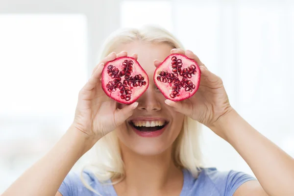 Mulher feliz cobrindo os olhos com romã — Fotografia de Stock