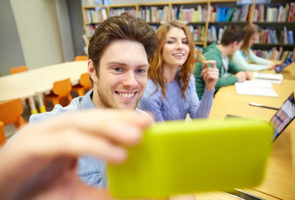 Studenci z smartphone przy selfie w bibliotece — Zdjęcie stockowe