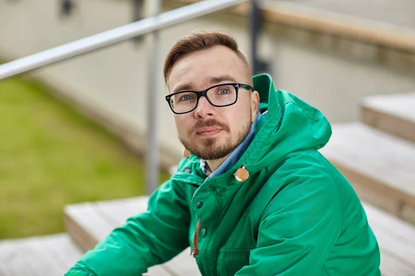 Gelukkig jonge hipster man zit op de trap in de stad — Stockfoto