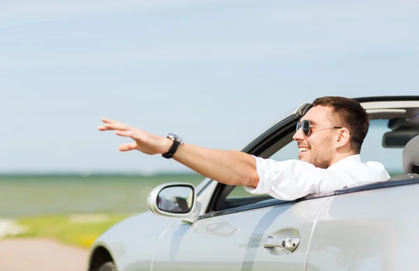 Homem feliz dirigindo carro cabriolet e mão acenando — Fotografia de Stock