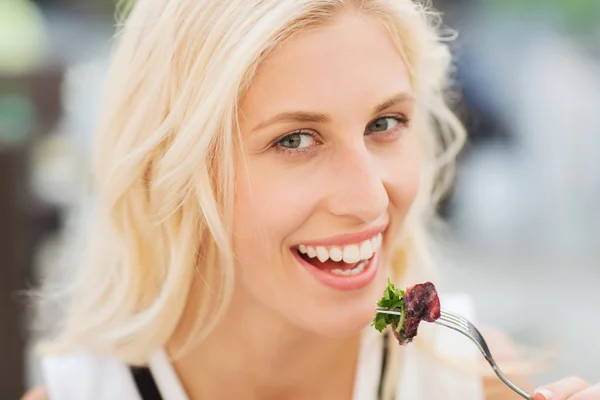 Gelukkige vrouw eten diner in restaurant terras — Stockfoto