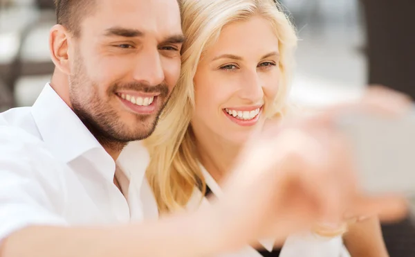 Casal feliz tomando selfie com smatphone ao ar livre — Fotografia de Stock