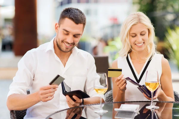 Pareja con tarjetas de crédito pagando factura en el restaurante — Foto de Stock