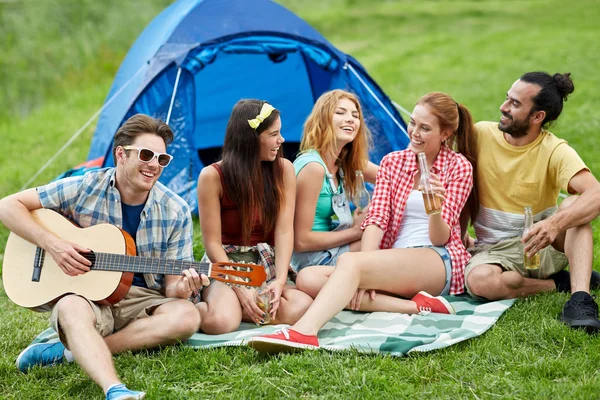 Amigos felices con bebidas y guitarra en el camping —  Fotos de Stock