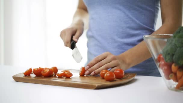 Крупним планом молода жінка нарізає помідори вдома — стокове відео