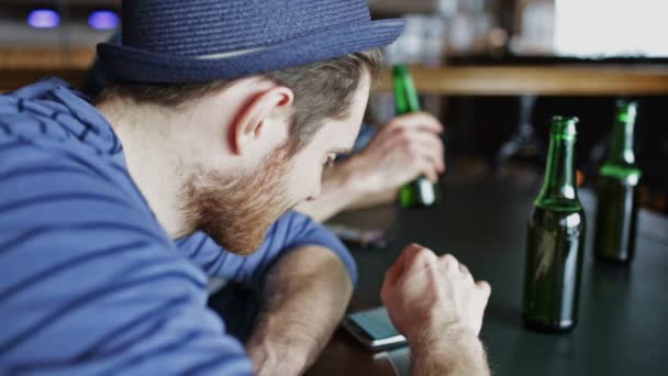 Amigos varones con smartphones bebiendo cerveza en el bar — Vídeo de stock