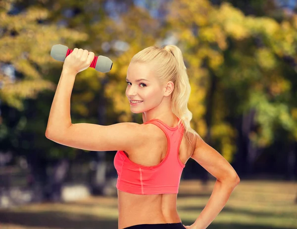 Jonge, sportieve vrouw met lichte dumbbell — Stockfoto