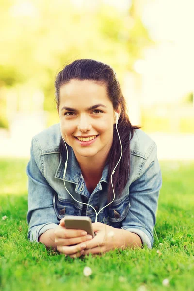 Sorridente ragazza con smartphone e auricolari — Foto Stock