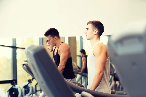 Grupp män tränar på löpband i gym — Stockfoto