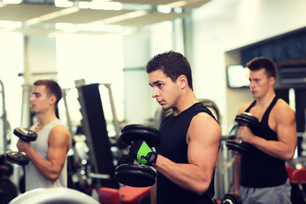 Groupe d'hommes avec haltères dans la salle de gym — Photo