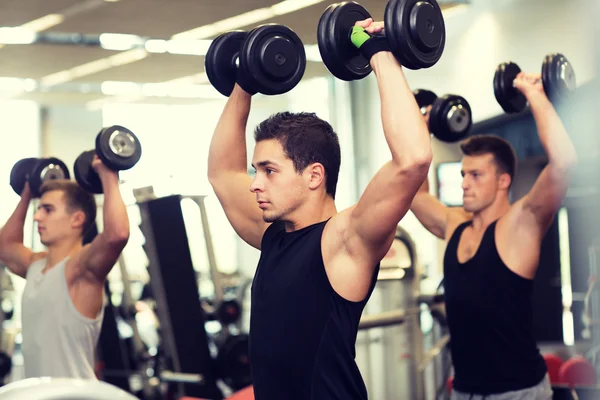 Gruppo di uomini con manubri in palestra — Foto Stock