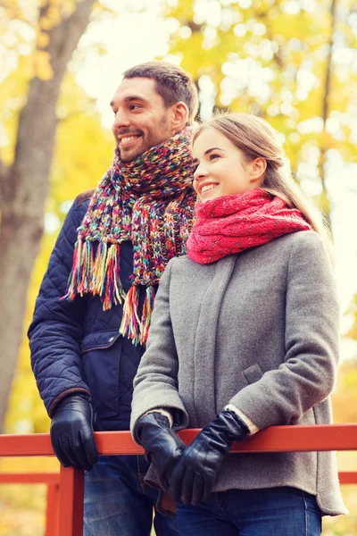 Lächelndes Paar umarmt sich auf Brücke im Herbstpark — Stockfoto