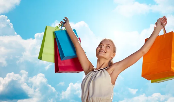 Mulher sorrindo com as mãos subindo saco de compras — Fotografia de Stock