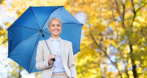 Geschäftsfrau mit Regenschirm über herbstlichem Hintergrund — Stockfoto