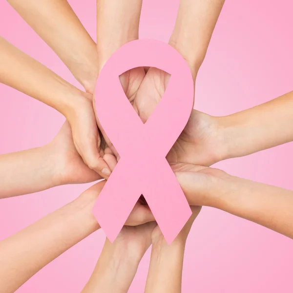 Close up of hands with cancer awareness symbol — Stock Photo, Image
