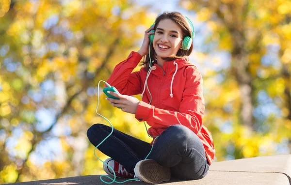 Glad ung kvinna med smartphone och hörlurar — Stockfoto