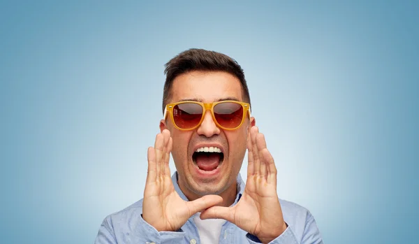 Face of angry shouting man in shirt and sunglasses — Stockfoto