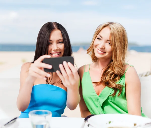 Tjejer tar foto i café på stranden — Stockfoto