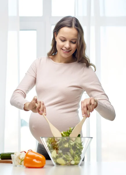 Happy těhotná žena připravuje jídlo doma — Stock fotografie