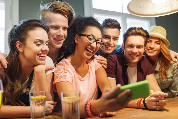 Amigos felices con teléfono inteligente tomar selfie en el bar —  Fotos de Stock