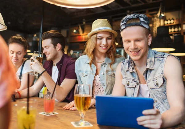 Amis heureux avec tablette pc et boissons au bar — Photo