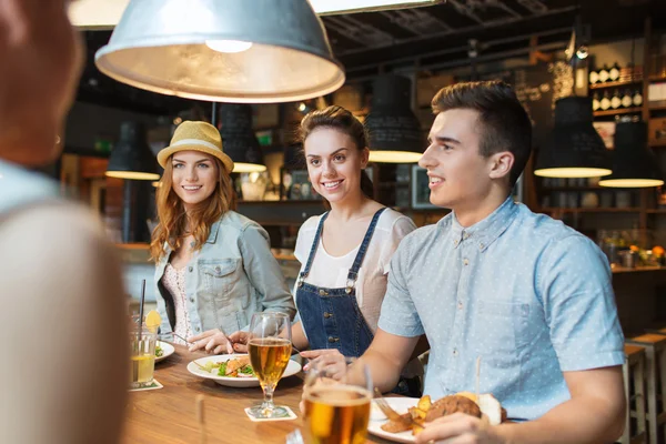 Happy přátelé, jídlo a pití na bar či hospodu — Stock fotografie