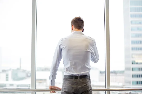 Affärsman uppmanar smartphone i office — Stockfoto