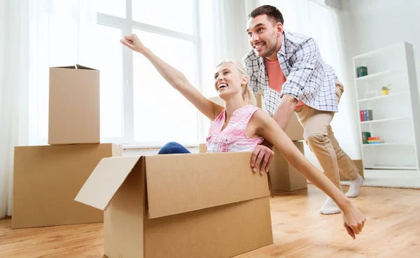 Pareja con cajas de cartón que se divierten en un nuevo hogar — Foto de Stock