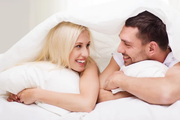 Casal feliz deitado na cama e falando em casa — Fotografia de Stock