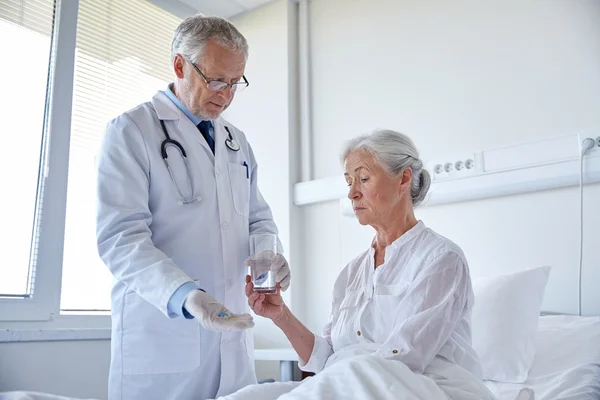 Médico dando remédio para a mulher idosa no hospital — Fotografia de Stock