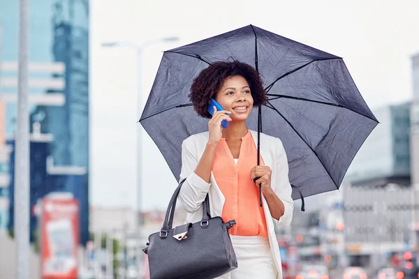 Geschäftsfrau mit Regenschirm ruft aufs Smartphone — Stockfoto